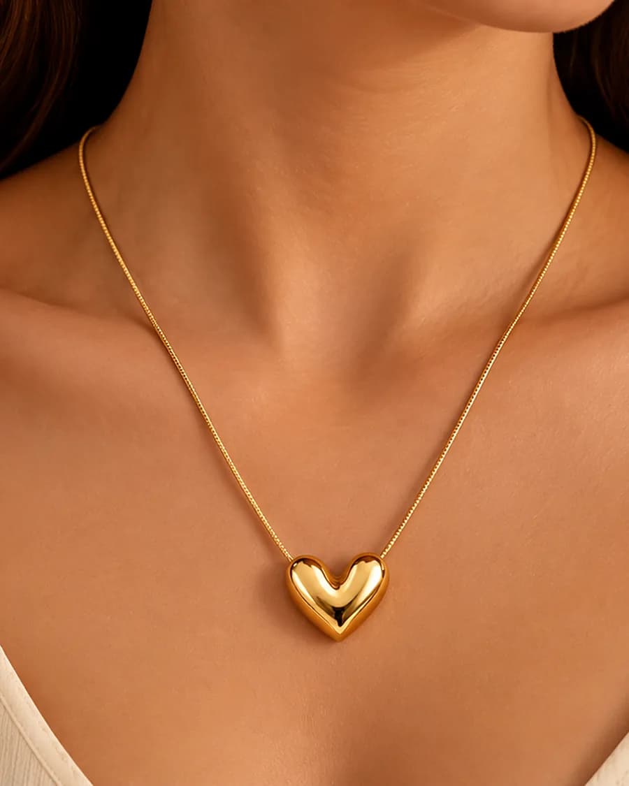 The Amour puffed heart pendant worn on a fine chain at the collarbone