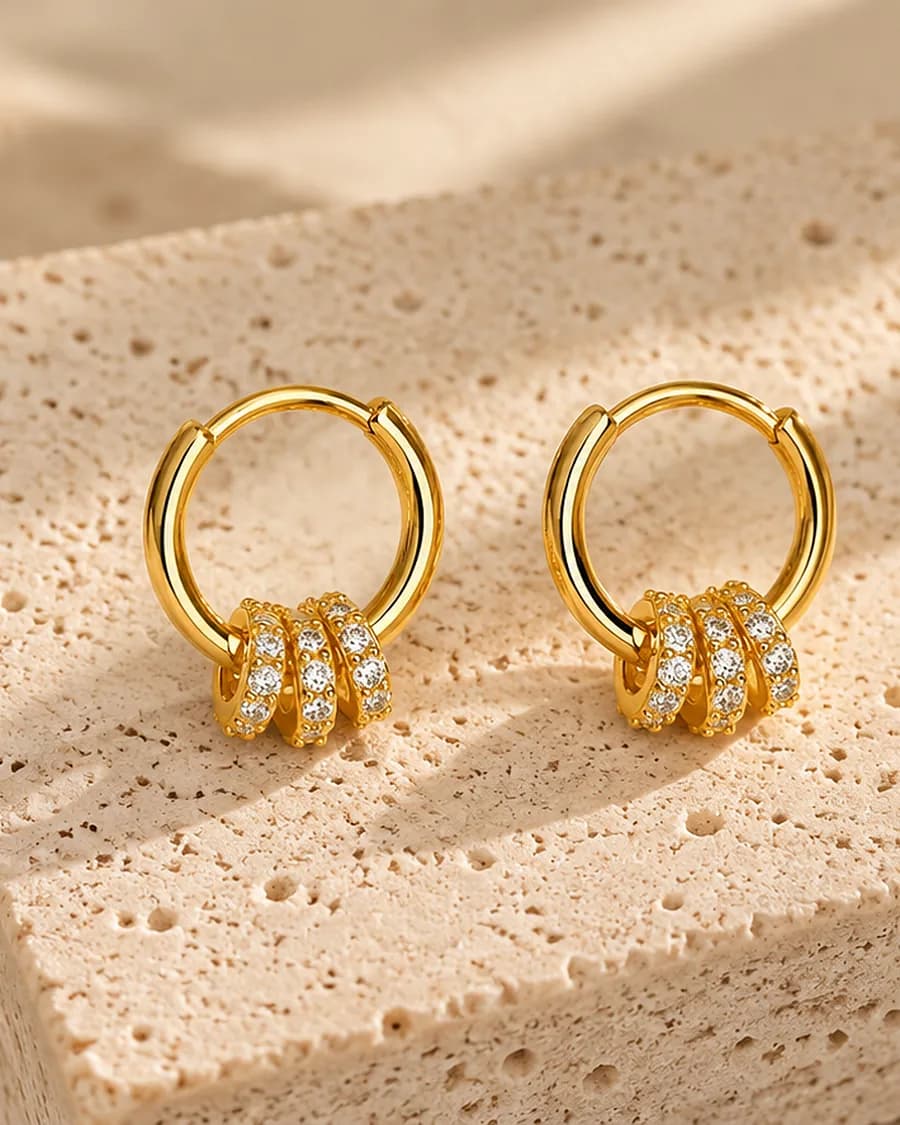 Éclat Trio Hoops photographed on a travertine block in warm daylight