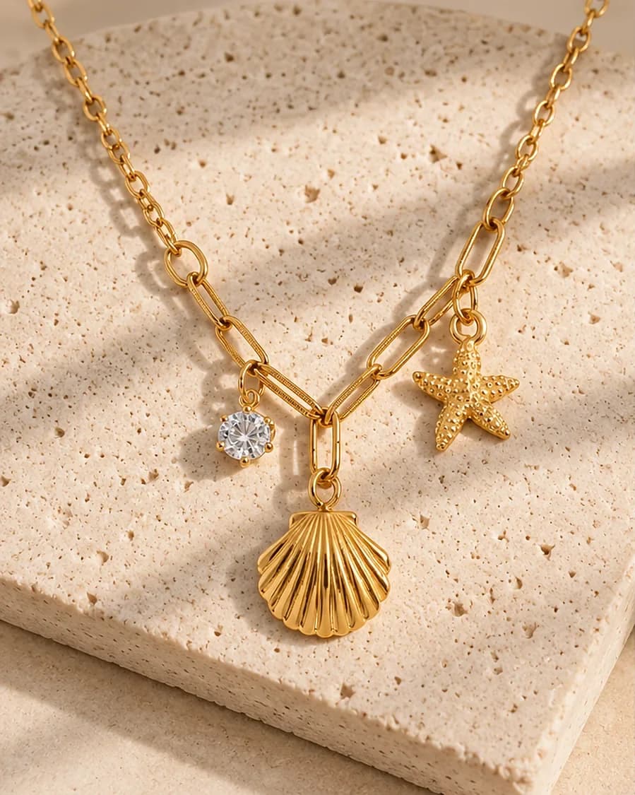 Ocean Charm Necklace photographed on a travertine block in warm daylight
