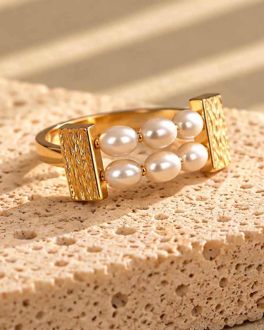The Freshwater Perle Line Ring photographed on a travertine block in warm daylight