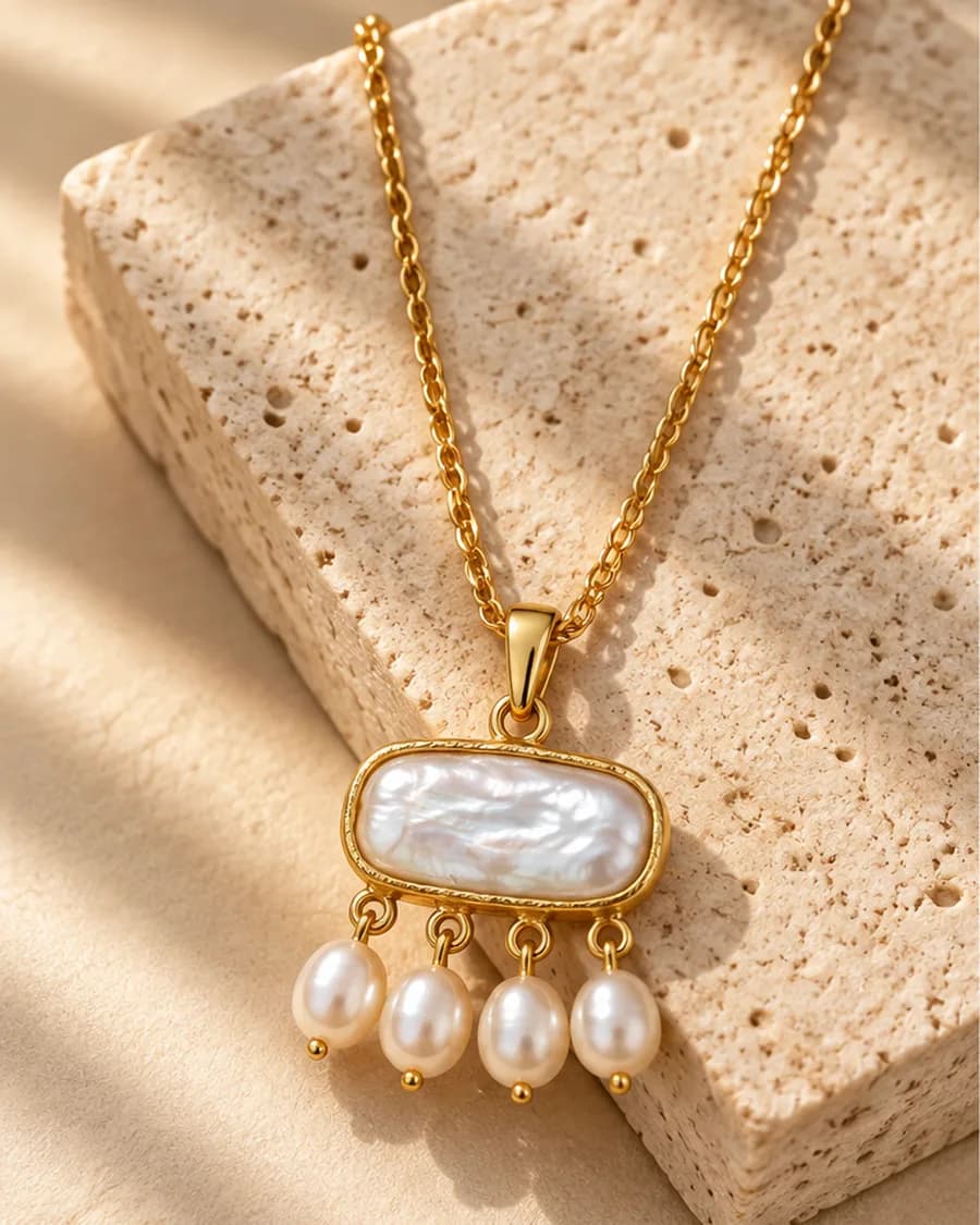 The Perle Cascade Necklace photographed on a travertine block in warm daylight