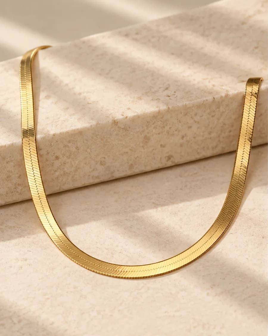 The Serpentine Necklace photographed on a travertine block in warm daylight