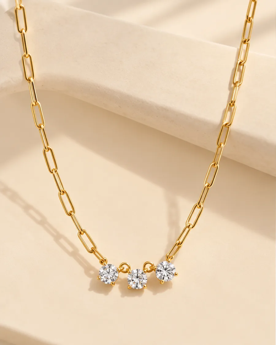 The Trio Spark Necklace photographed on a travertine block in warm daylight