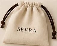 The cream SÉVRA drawstring pouch with its brown cord ties