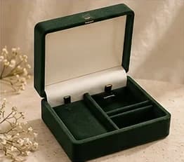 An open dark green velvet SÉVRA gift box with a cream lining and compartments