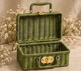An open olive woven SÉVRA gift basket with a brass clasp and handle