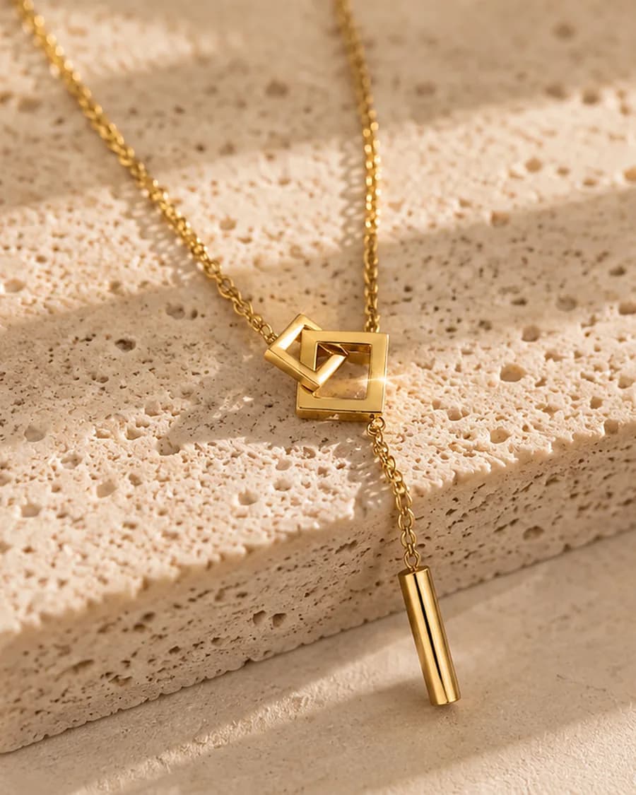 Axis Necklace photographed on a travertine block in warm daylight