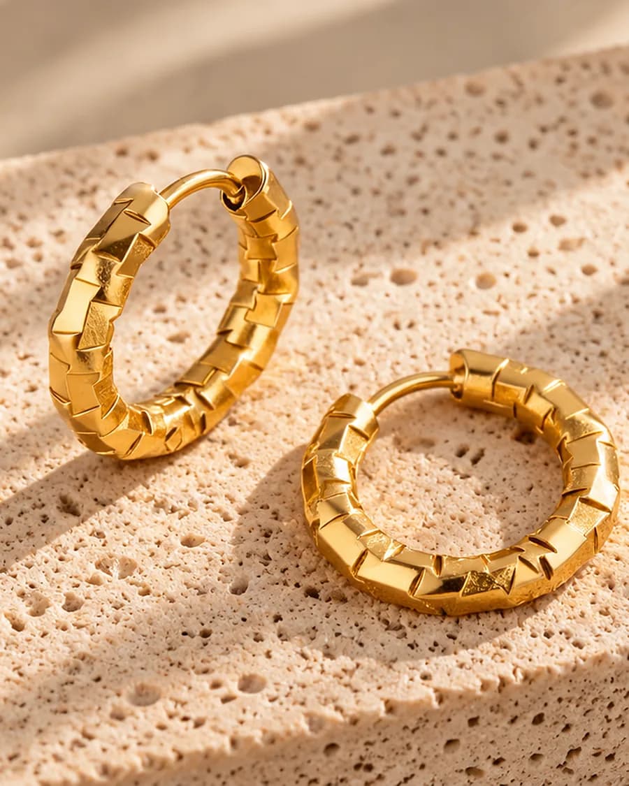 Facette Hoops photographed on a travertine block in warm daylight