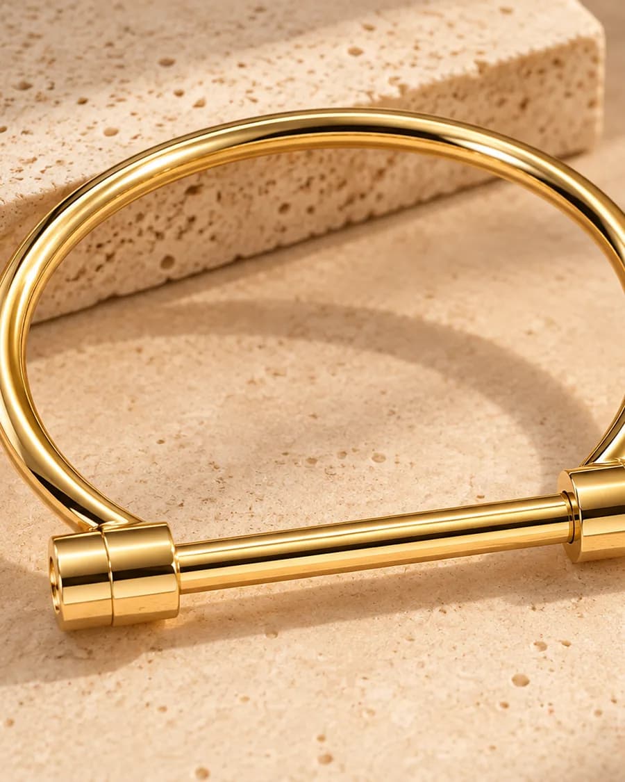 The Aurex Nail Set bangle photographed on a travertine block in warm daylight