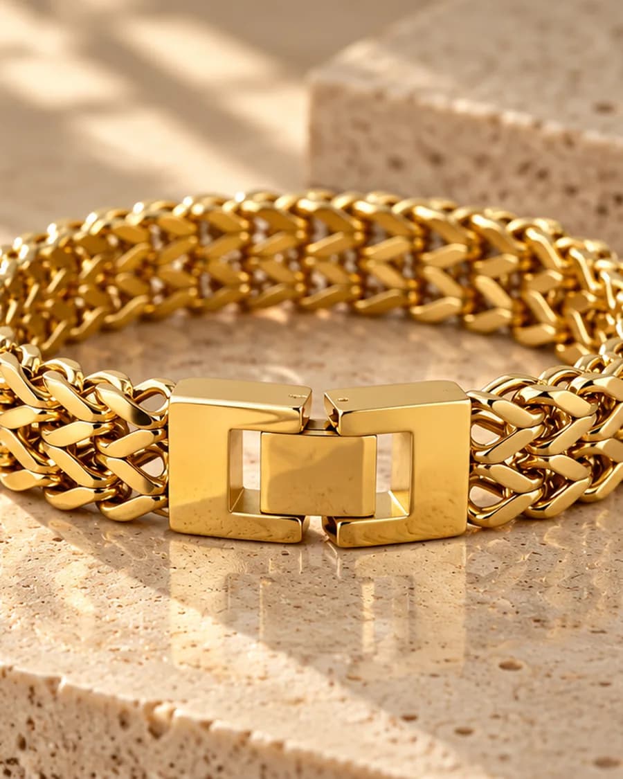 The Interlock Chain Bracelet photographed on a travertine block in warm daylight
